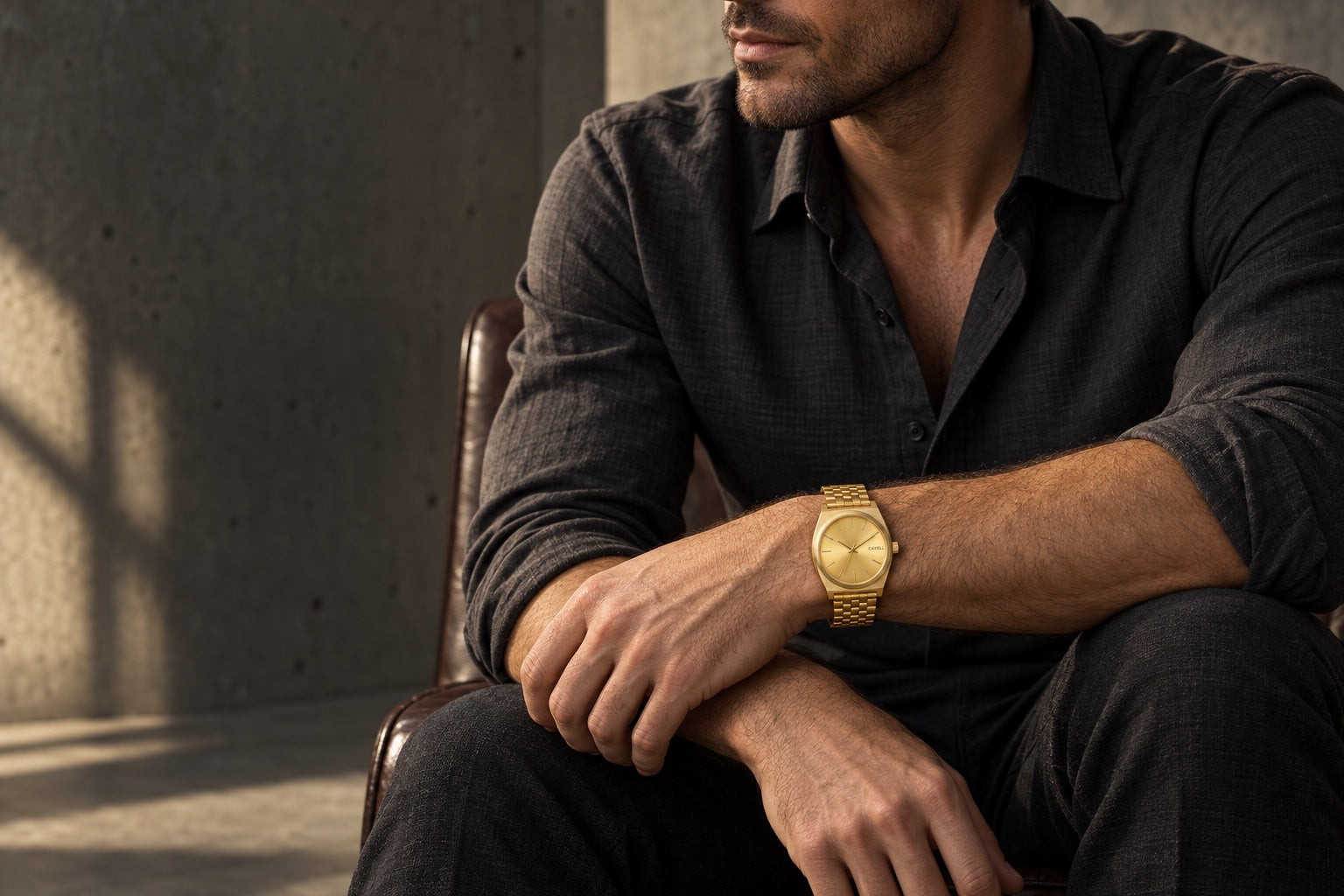 Gold CAVELL Time Teller worn with a charcoal shirt in a sunlit architectural interior